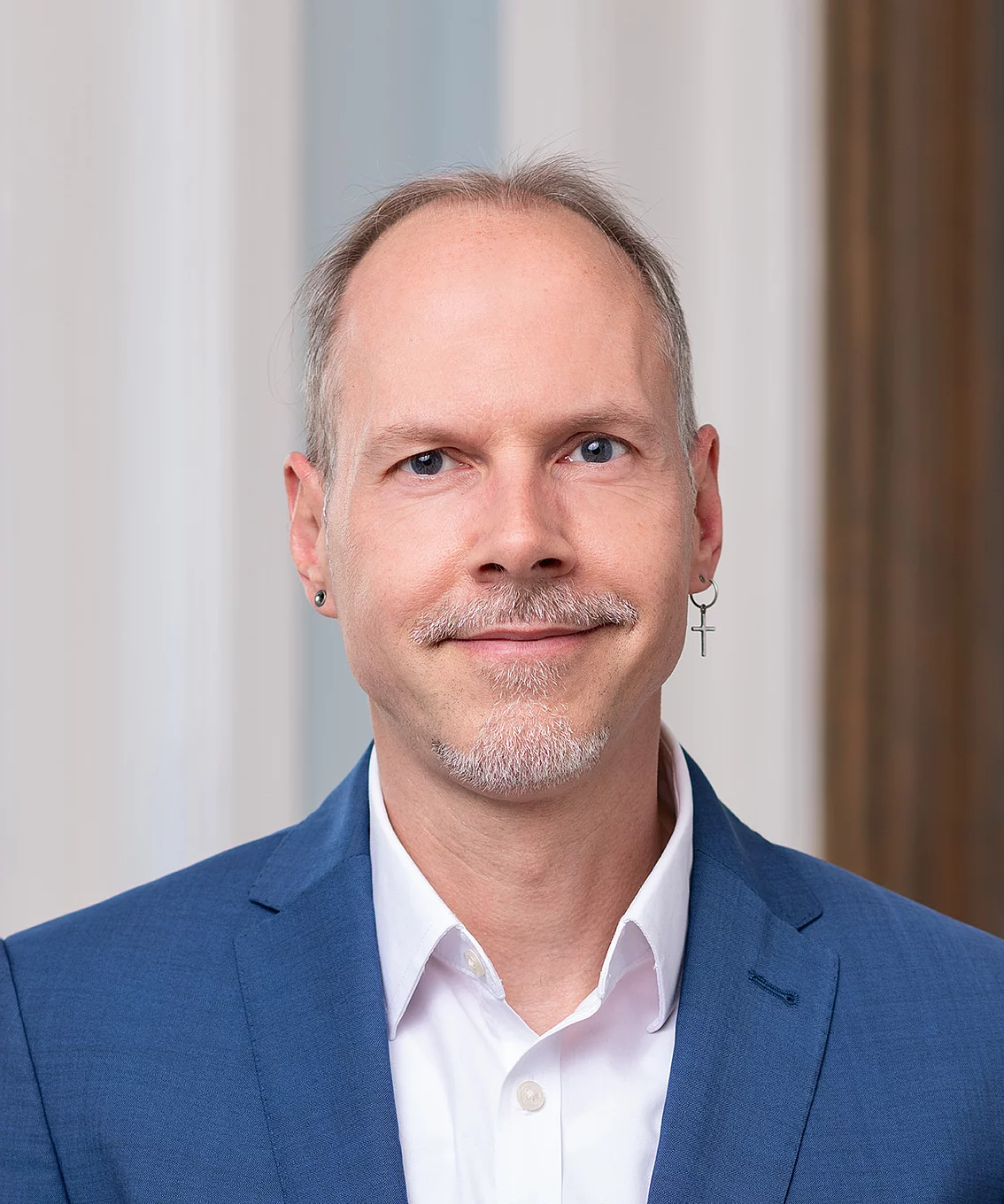 men with grey hair in a suit smiling