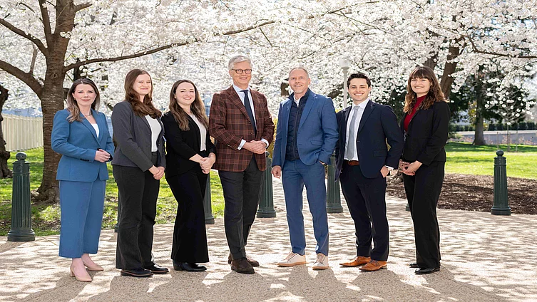 seven colleagues in business attire in front of cherry blossoms