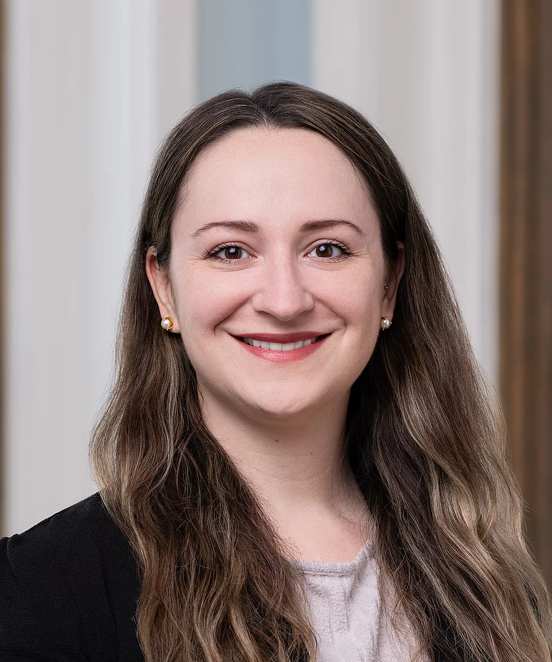 close up headshot of smiling woman with brown hair and brown eyes.